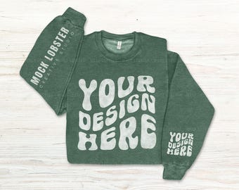 May include: A green long-sleeve sweatshirt with a white "Your Design Here" graphic in a retro font. The sweatshirt has a distressed look and is perfect for customizing.