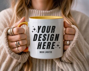 May include: A white ceramic mug with a yellow rim and handle. The mug has black text that says "YOUR DESIGN HERE" and "MOCK LOBSTER CREATIVE STUDIO".