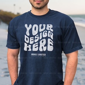 May include: A navy blue t-shirt with a white graphic that says "YOUR DESIGN HERE" and "MOCK LOBSTER CREATIVE STUDIO".