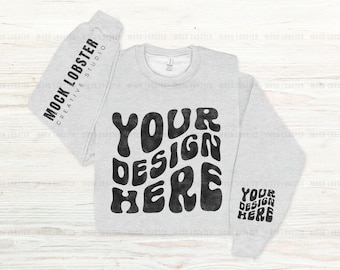 Maqueta de sudadera Gildan 18000 con mangas en color ceniza, diseño plano, con estampado de mangas izquierda y derecha, maqueta de sudadera Gildan G180 con cuello redondo y dobladillo doblado.