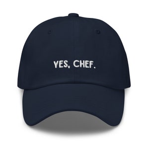 May include: A navy blue baseball cap with white embroidered text that reads "YES, CHEF."