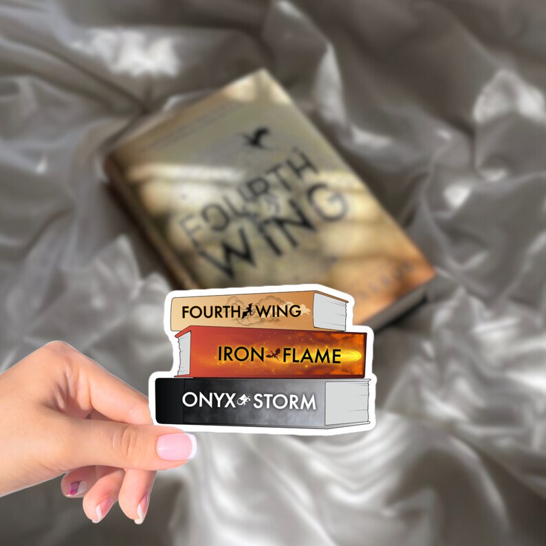 Op de afbeelding: Een sticker met drie boekomslagen uit de "Throne of Glass" serie van Sarah J. Maas. De omslagen zijn op elkaar gestapeld en dragen de titels "Fourth Wing", "Iron Flame" en "Onyx Storm".