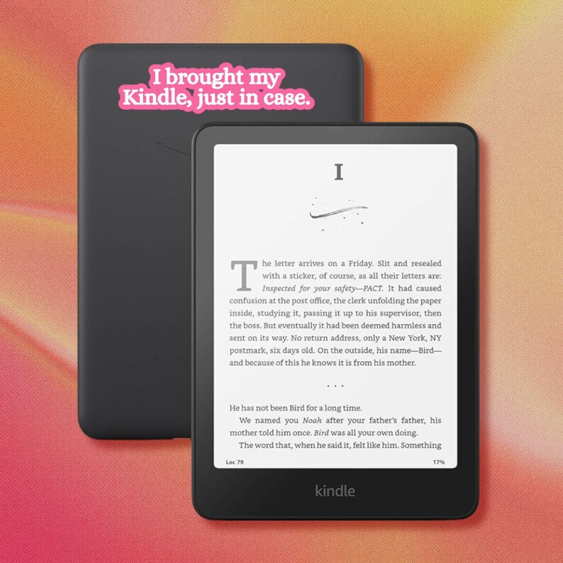 May include: Two black e-readers, one showing a page of text and the other displaying a pink sticker that reads, "I brought my Kindle, just in case." The devices have a matte finish, thin bezels, and the word "kindle" printed at the bottom center.
