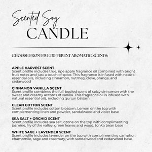 May include: A white card with black text describing five different scented soy candle fragrances: Apple Harvest, Cinnamon Vanilla, Clean Cotton, Sea Salt + Orchid, and White Sage + Lavender.
