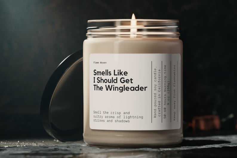 May include: A glass jar candle with a white label that reads "Smells Like I Should Get The Wingleader". The candle is hand-poured soy and crafted in California. It has a burn time of 50-60 hours and is 9 ounces.