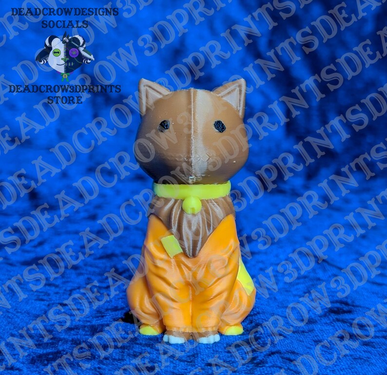May include: A 3D printed figurine of a brown dog with pointed ears and black eyes. The dog wears a bright yellow collar with a small bell and an orange jumpsuit with a yellow patch on the chest. The figure has a visible vertical seam line.