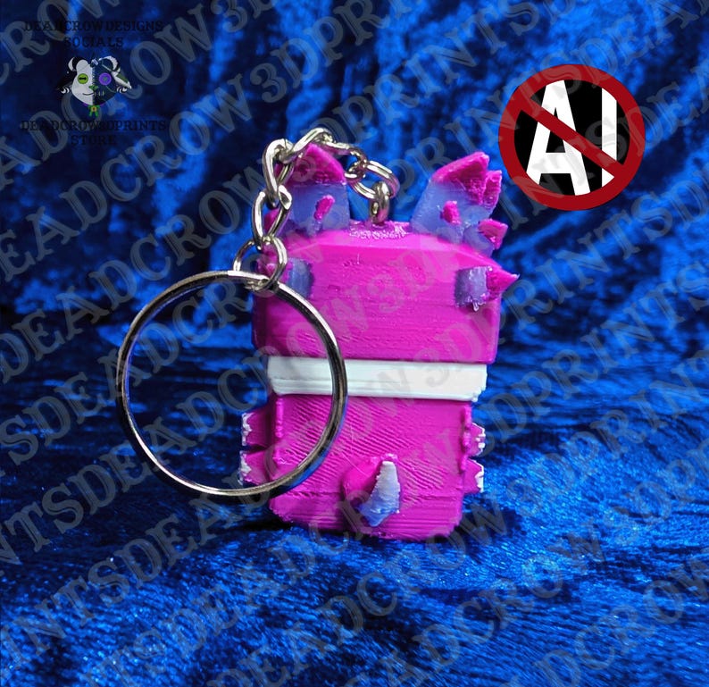 May include: A 3D-printed keychain featuring a bright pink blocky character with a white horizontal stripe across the middle. The figure has small purple-tipped ears and a purple-tipped tail, attached to a silver metal split ring keychain.