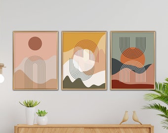 May include: Three abstract art prints featuring geometric shapes and colours, hung on a white wall above a wooden cabinet with a plant in a woven basket.