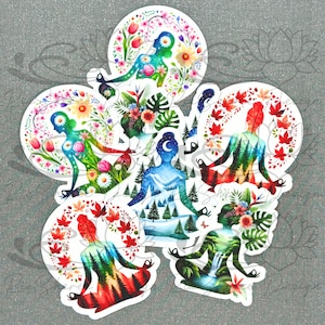 May include: Six colorful watercolor stickers featuring a woman in a yoga pose surrounded by flowers, leaves, and other nature-inspired elements. Each sticker has a different color scheme and design, representing different seasons or elements.
