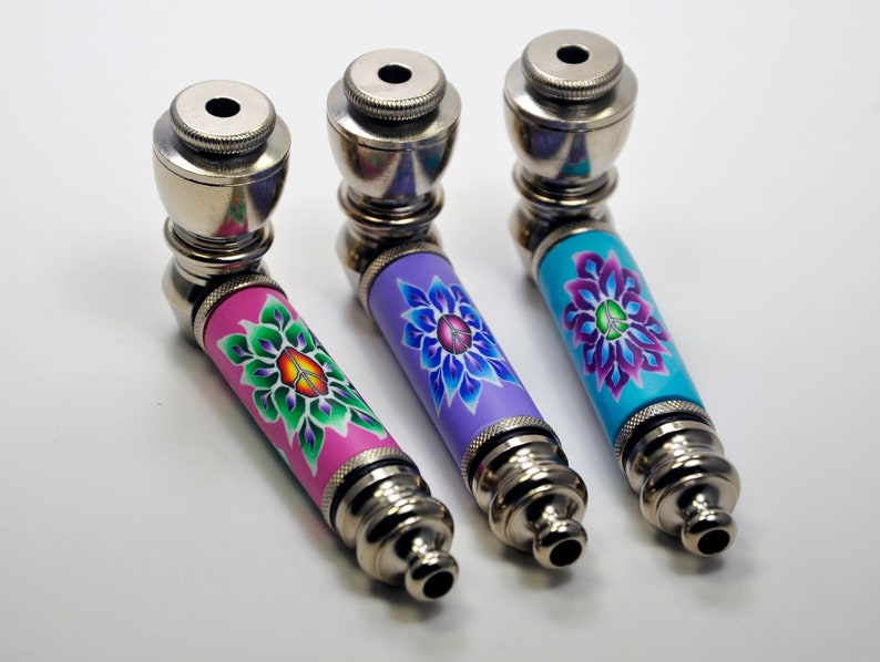 May include: Three metal pipes with colourful floral designs. The pipes are silver with a pink, purple, and blue floral design.
