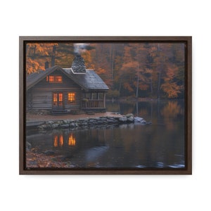 May include: A rustic wooden cabin with lit windows sits on a small island in a lake surrounded by fall foliage. The lake is calm and reflects the cabin and the trees.