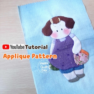 Op de afbeelding: Een applicatiepatroon van een meisje met bruin haar dat een bloemen tas vasthoudt. Het patroon is op een lichtblauwe achtergrond. De tekst "YouTube Tutorial Applique Pattern" staat onderaan de afbeelding.