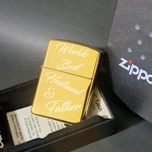 May include: Gold Zippo lighter with an engraved inscription that reads "Worlds Best Husband & Father".