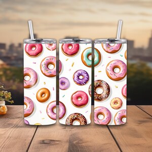 May include: Three stainless steel tumblers with a white background and a repeating pattern of colorful donuts with sprinkles.
