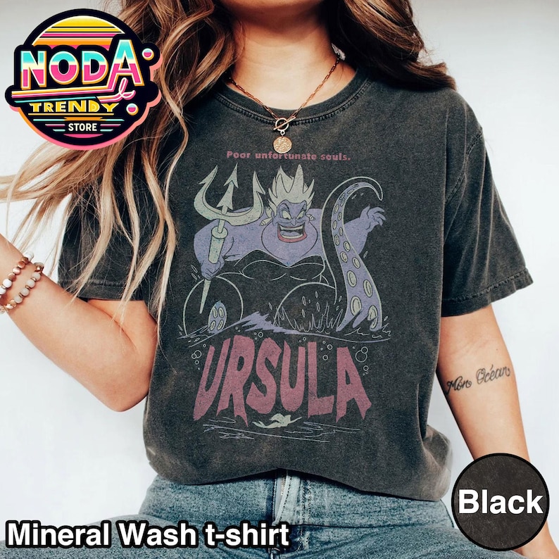 May include: Black mineral wash t-shirt featuring a graphic of Ursula from The Little Mermaid, with the text "Poor unfortunate souls" above and "URSULA" below. The shirt has a vintage look.