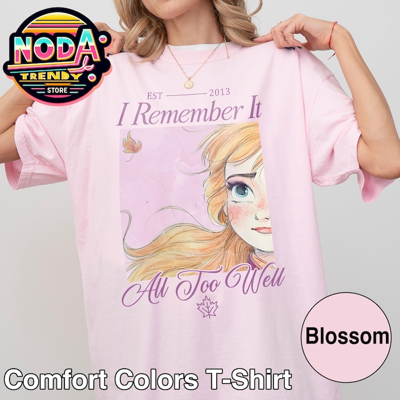 Puede incluir: Camiseta Comfort Colors rosa claro con el texto "I Remember It All Too Well" y un dibujo animado. La camiseta tambi&eacute;n presenta el texto "EST 2013" y la palabra "Blossom" en un c&iacute;rculo.