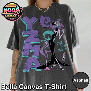 Pu&ograve; includere: T-shirt Bella Canvas color asfalto con grafica di Yzma de Le follie dell'imperatore di Disney. Il design include la parola "Yzma" in viola e verde acqua, con la frase "Pick Your Poison" e una bottiglia di veleno.