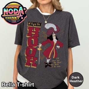 May include: Dark heather Bella T-shirt featuring a Captain Hook graphic. The design includes the word "CAPTAIN HOOK" in a bold font, and an illustration of Captain Hook in a red coat. The shirt also has the text "I'll show you this ghost has blood in his veins."