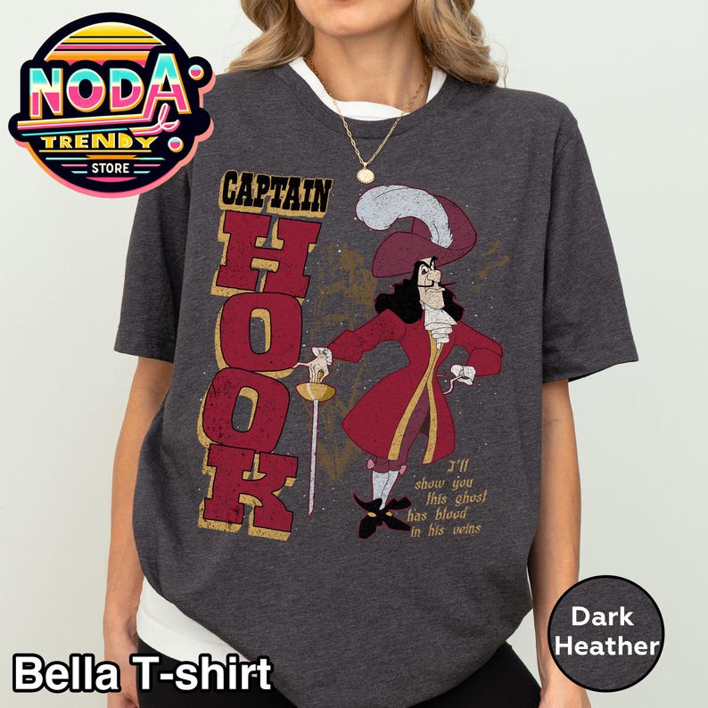 May include: Dark heather Bella T-shirt featuring a Captain Hook graphic. The design includes the word "CAPTAIN HOOK" in a bold font, and an illustration of Captain Hook in a red coat. The shirt also has the text "I'll show you this ghost has blood in his veins."