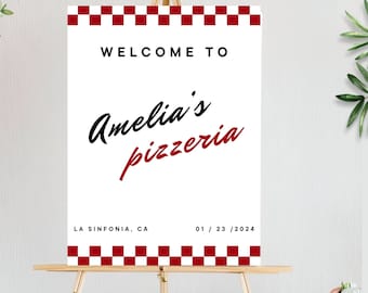 Peut inclure: Une pancarte blanche avec des bordures à carreaux rouges et le texte "Bienvenue chez Amelia's Pizzeria" en lettres noires et rouges. La pancarte indique également l'emplacement "La Sinfonia, CA" et la date "01/23/2024".