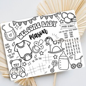 May include: A black and white printable baby shower game with a welcome baby Mason banner, a word search, tic-tac-toe, and other baby-themed images.