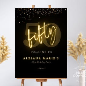 May include: A black and gold 50th birthday party welcome sign. The word "fifty" is in a glowing gold script font, with the number 50 in a gold outline. The sign includes the text "Welcome to Alesana Marie's 50th Birthday Party" and the date.