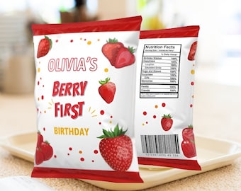 Puede incluir: Bolsa de chips roja y blanca con un diseño de fresa. La bolsa dice "Olivia's Berry First Birthday".