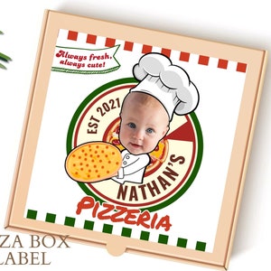 Puede incluir: Una etiqueta de caja de pizza con una ilustración de dibujos animados de un bebé con un gorro de cocinero y sosteniendo una pizza. El texto de la etiqueta dice "Nathan's Pizzeria Est 2021 Siempre fresco, siempre lindo!"