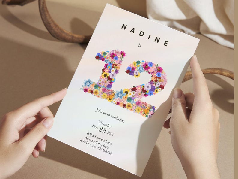 May include: A white invitation card with a floral design in the shape of the number 12. The text "Nadine is" is at the top of the card. The invitation is for a birthday party on Thursday, November 23, 2024.