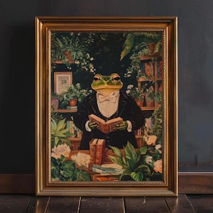 May include: Framed artwork featuring a frog in a tuxedo reading a book. The frog is green with a white bow tie, set against a backdrop of plants and bookshelves. The frame is gold-colored.