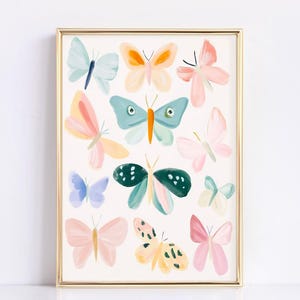 May include: A framed art print featuring a collection of colorful butterfly illustrations. The butterflies are painted in various pastel shades, including pink, blue, yellow, and green, with a gold frame.