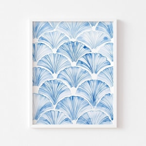 Op de afbeelding: Een ingelijste kunstdruk met een herhalend patroon van blauwe waaiervormige ontwerpen op een witte achtergrond. Het kunstwerk in aquarelstijl is ingesloten in een witte lijst, wat een strakke en moderne esthetiek creëert. Geschikt voor interieurdecoratie.