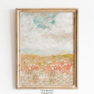 Puede incluir: Pintura de paisaje enmarcada, de estilo impresionista suave. La obra representa un campo de flores silvestres en tonos rosas y blancos, bajo un cielo de nubes azules y blancas. El marco es de color madera clara y natural. El texto "ITEMSSY - CRAFTS -" está en la parte inferior.
