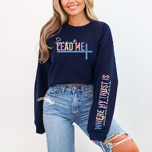Puede incluir: Sudadera azul marino recortada con el texto "Spirit Lead Me" en colores arcoíris en la parte delantera y "Where My Trust Is" en colores arcoíris en la manga.