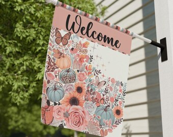 May include: A decorative garden flag with the word "Welcome" in black script. The flag features a floral and pumpkin design in shades of orange, pink, and teal. The flag measures 24.5" x 32".