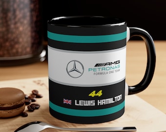 May include: Black ceramic mug with a Formula One racing theme. It features the Mercedes-AMG Petronas Formula One Team logo, the number 44, and the name Lewis Hamilton.