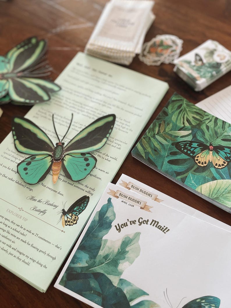 May include: A collection of stationery items featuring butterfly and tropical leaf designs. Includes a notepad, notecards, stickers, and decorative butterfly cutouts. The notepad has text that reads "How the Birdwing Butterfly" and "You've Got Mail!"
