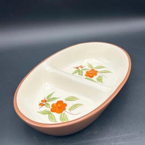 Puede incluir: Un plato de servir dividido con un borde marrón y un interior blanco. El plato está decorado con flores naranjas y hojas verdes.