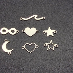 Könnte beinhalten: Silberfarbene Charms in verschiedenen Formen: Welle, Unendlichkeitssymbol, massives Herz, Stern, offenes Herz, Halbmond und Sternkontur. Geeignet für Schmuckherstellung oder Bastelprojekte.