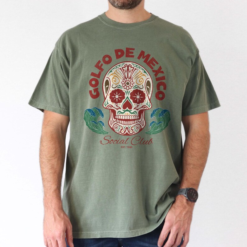 May include: A green t-shirt with a colorful sugar skull graphic and the text "Golfo de Mexico Social Club Est. 1930".