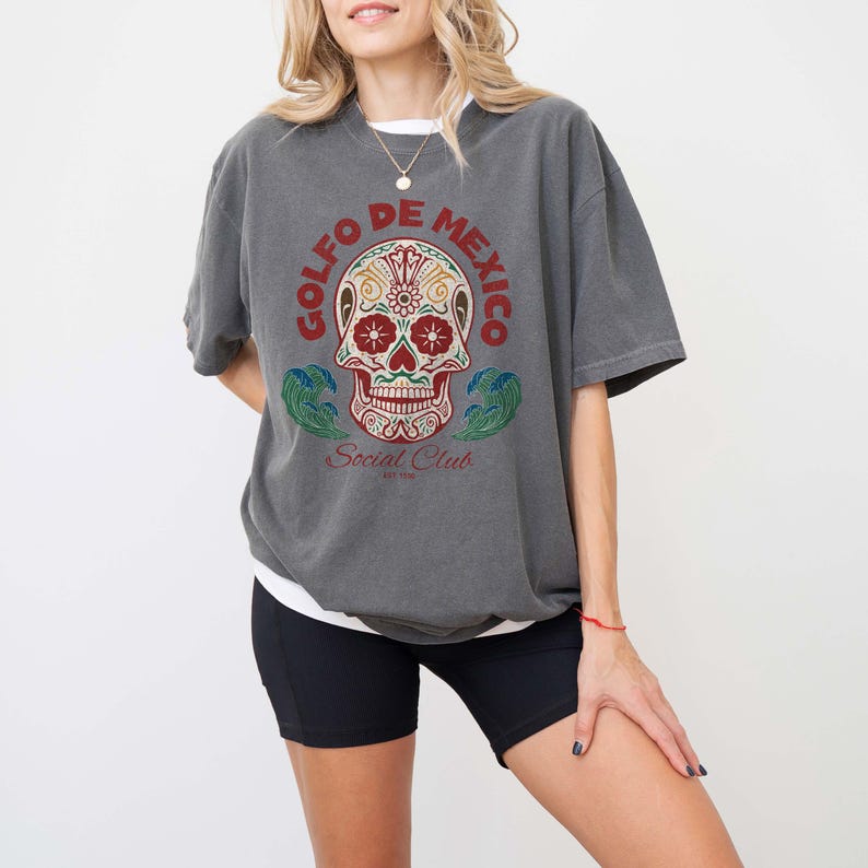 May include: Gray t-shirt with a colorful sugar skull graphic and the text "Golfo de Mexico Social Club Est. 1992".