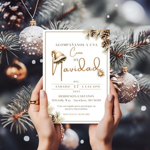 Puede incluir: Una invitación de Navidad blanca con letras doradas. La invitación dice "Acompáñanos a una Cena de Navidad" con la fecha y la hora del evento. La invitación también incluye la dirección y la información de RSVP.