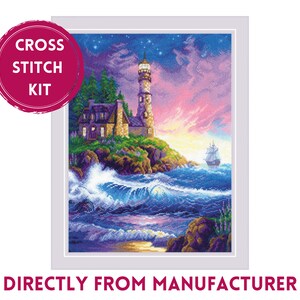 May include: Cross stitch kit featuring a lighthouse on a rocky shore with a sailboat in the distance. The sky is a vibrant pink and purple with stars. The lighthouse is white with a black roof and a light on top. The water is blue and green with white waves.