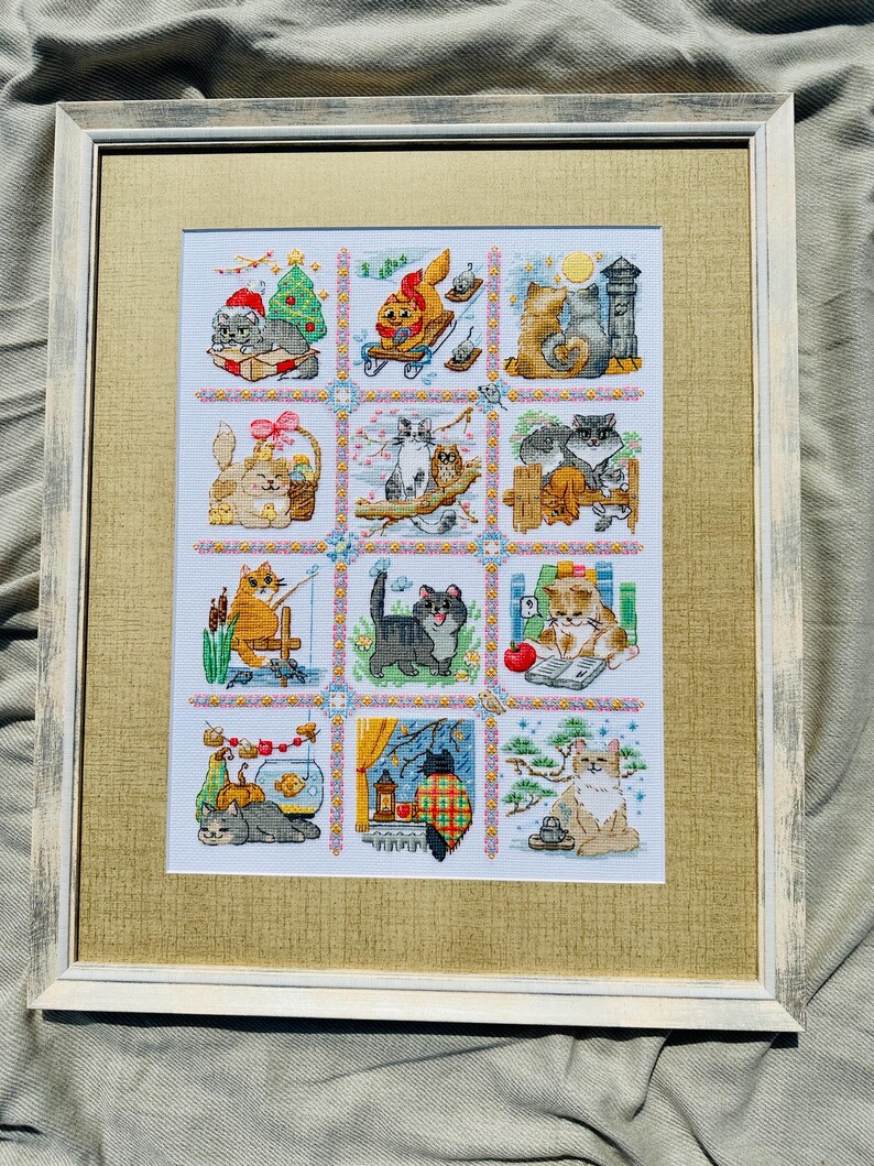 The RIOLIS cross stitch kit Cat Calendar features a charming calendar design with cats, using 29 colors of wool/acrylic threads. The kit includes a needle, Zweigart 14ct white AIDA fabric, and a color chart. The finished size is 30x40 cm.
