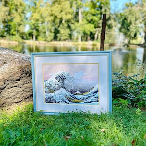 The RIOLIS cross stitch kit The Great Wave off Kanagawa after K. Hokusai Artwork features a detailed design using 17 colors of Anchor stranded cotton threads. The kit includes a needle, Zweigart 14ct white AIDA fabric, and a color chart.