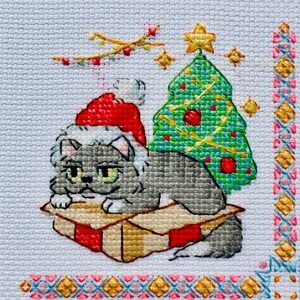 The RIOLIS cross stitch kit Cat Calendar features a charming calendar design with cats, using 29 colors of wool/acrylic threads. The kit includes a needle, Zweigart 14ct white AIDA fabric, and a color chart. The finished size is 30x40 cm.