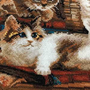 The RIOLIS cross stitch kit Furry Friends features beautiful three kittens playing. The kit includes wool acrylic threads in 20 colors, a needle, Zweigart 14ct flaxen AIDA fabric and a color chart. The finished size is 40x30 cm