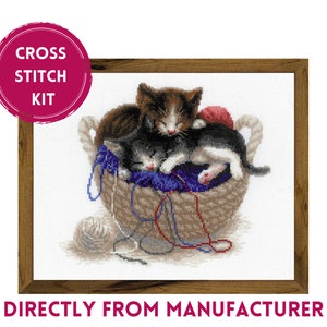 May include: Cross stitch kit featuring two kittens sleeping in a basket with yarn and needles. The kittens are brown, black, and white. The basket is brown and wicker.