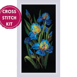 May include: A cross stitch kit featuring a rectangular design of vibrant blue iris flowers with yellow centers and green stems against a solid black background. A pink circular badge in the upper left corner displays the text CROSS STITCH KIT.