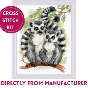 May include: Cross stitch kit featuring two lemur monkeys sitting on a branch. The lemurs are white and gray with black stripes on their tails. The background is a green and brown forest.